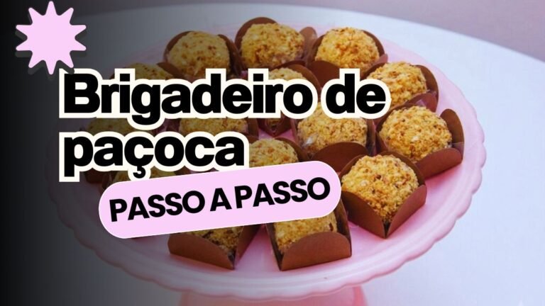 Boleira de cerâmica rosa bebê com vários brigadeiros de paçoca gourmet organizados em forminhas quadradas marrons. Os docinhos artesanais estão enrolados em amendoim triturado, perfeitos para festas e encomendas lucrativas.