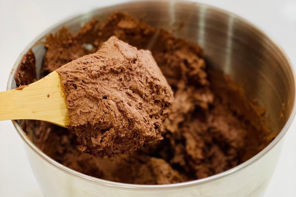 Mousse de chocolate brilhante e cremosa na batedeira, ilustrando o ponto correto do preparo.