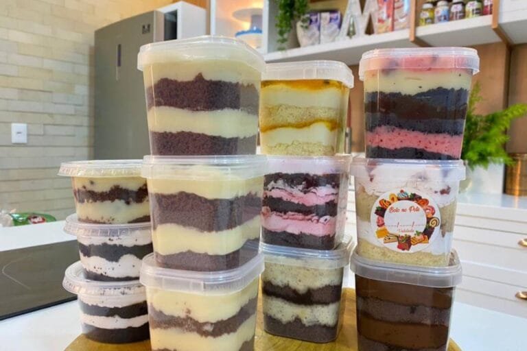 Vários sabores de bolo de pote mais vendidos alinhados em uma bancada, mostrando a variedade de um cardápio lucrativo para vender.