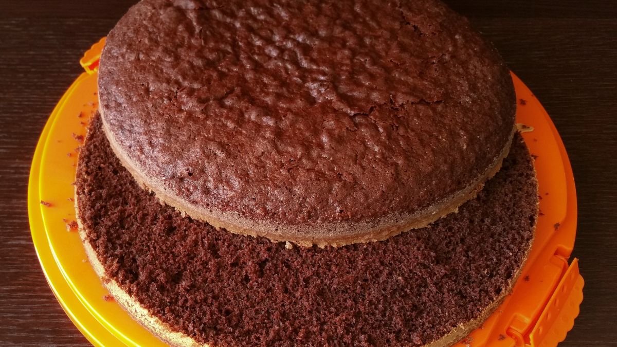 Close-up mostrando a textura da melhor massa de chocolate para bolo no pote, destacando sua fofura e umidade.