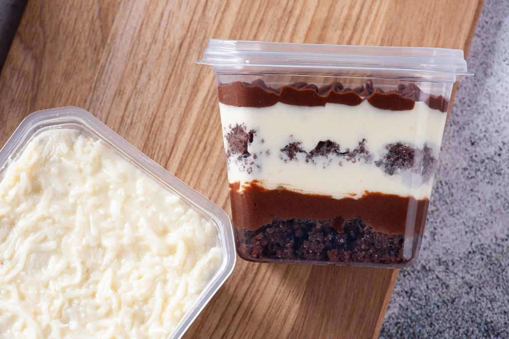 Foto com dois sabores de bolo no pote mais vendidos, mostrando a variedade de um cardápio para quem quer vender doces.