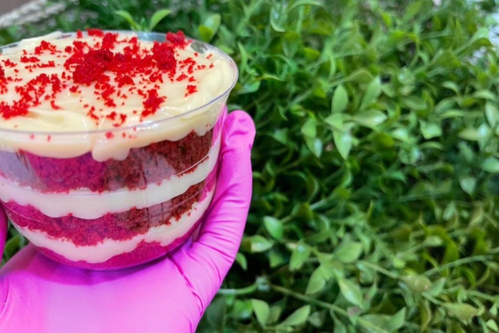 Close-up de um bolo de pote de red velvet, um dos sabores de bolo de pote mais vendidos para quem quer montar um cardápio de sucesso.
