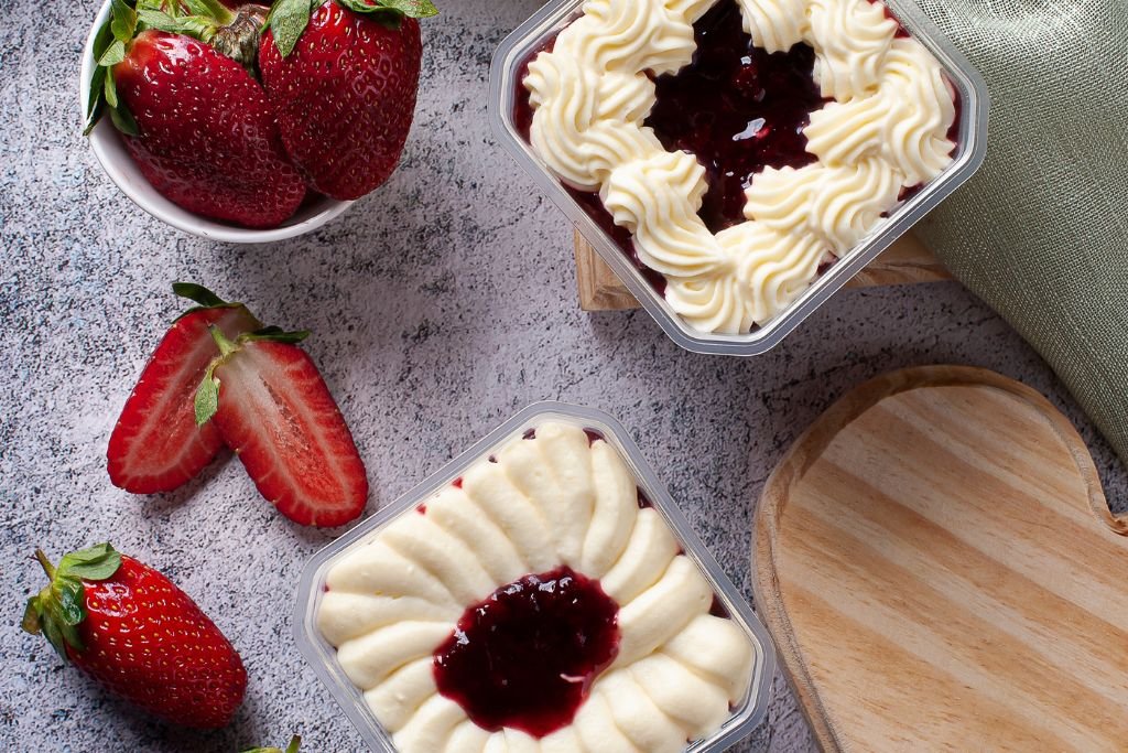 Confeiteira usando luz natural para tirar uma foto atraente de bolo de pote para vender no Instagram.