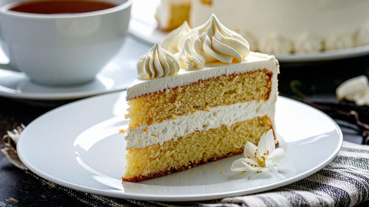Fatia de bolo de massa branca com recheio de ninho, ilustrando as melhores combinações para bolos.